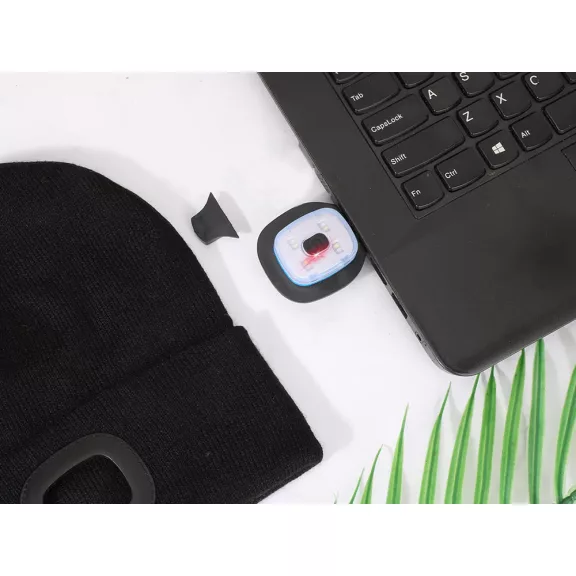 Fekete színű kötött téli sapka homlokrészébe épített, levehető és USB-ről tölthető téglalap alakú LED lámpával