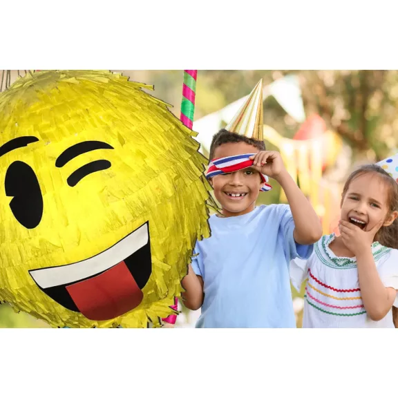 Színes Smiley pinyáta édességekkel töltve egy vidám születésnapi bulin.