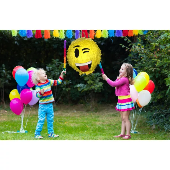 Színes Smiley pinyáta édességekkel töltve egy vidám születésnapi bulin.