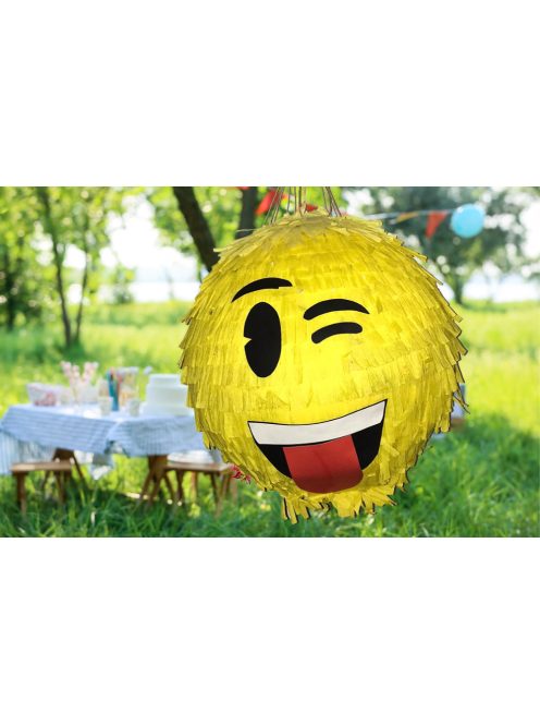 Színes Smiley pinyáta édességekkel töltve egy vidám születésnapi bulin.